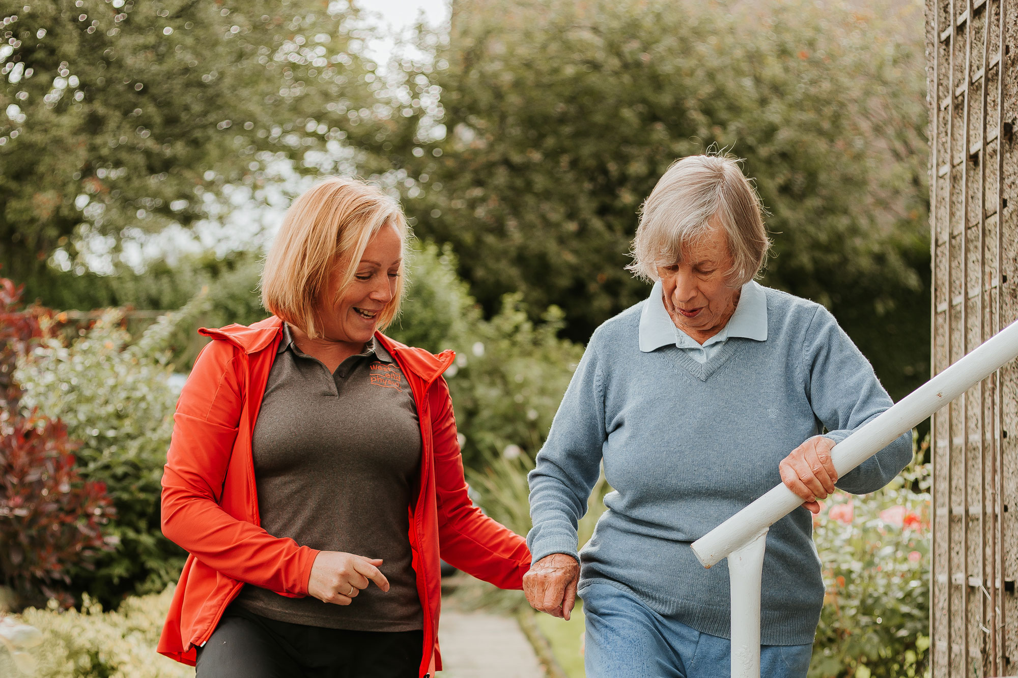 West End physiotherapist assisting a patient with an outdoor mobility assessment during a home visit, focusing on balance and movement